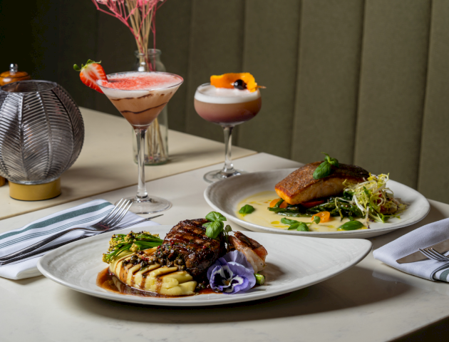 A plated meal with two side dishes, wine glass, and a napkin on a table in a restaurant. Top it at 140 characters, always ending the sentence.